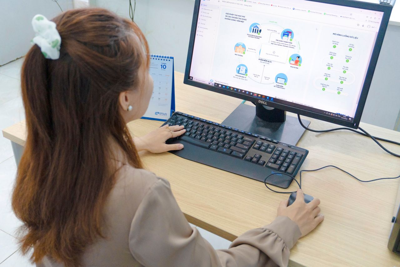 Young woman using desktop computer in office setting in Hanoi, Vietnam.